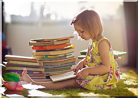 Girl sitting on a rug reads books