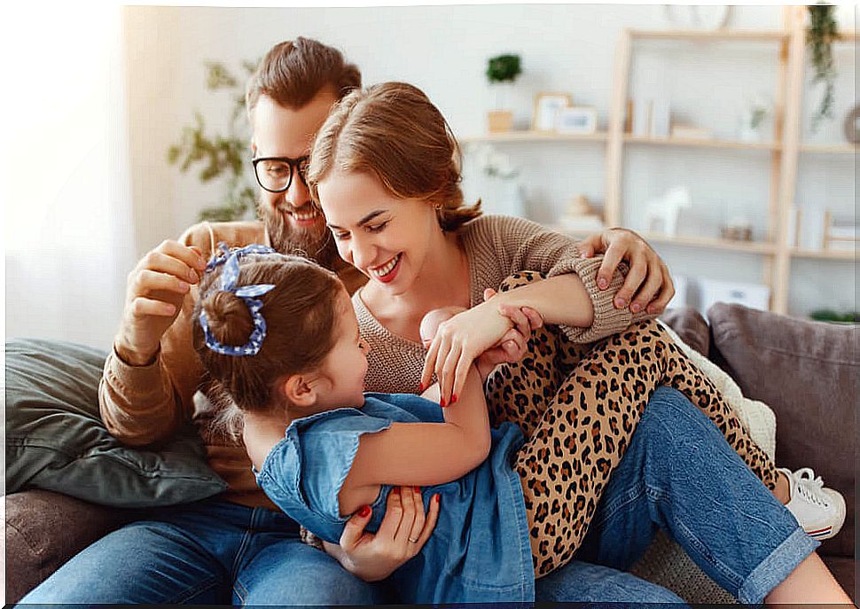 Parents tickling their daughter on the couch to strengthen family bonds in times of crisis.