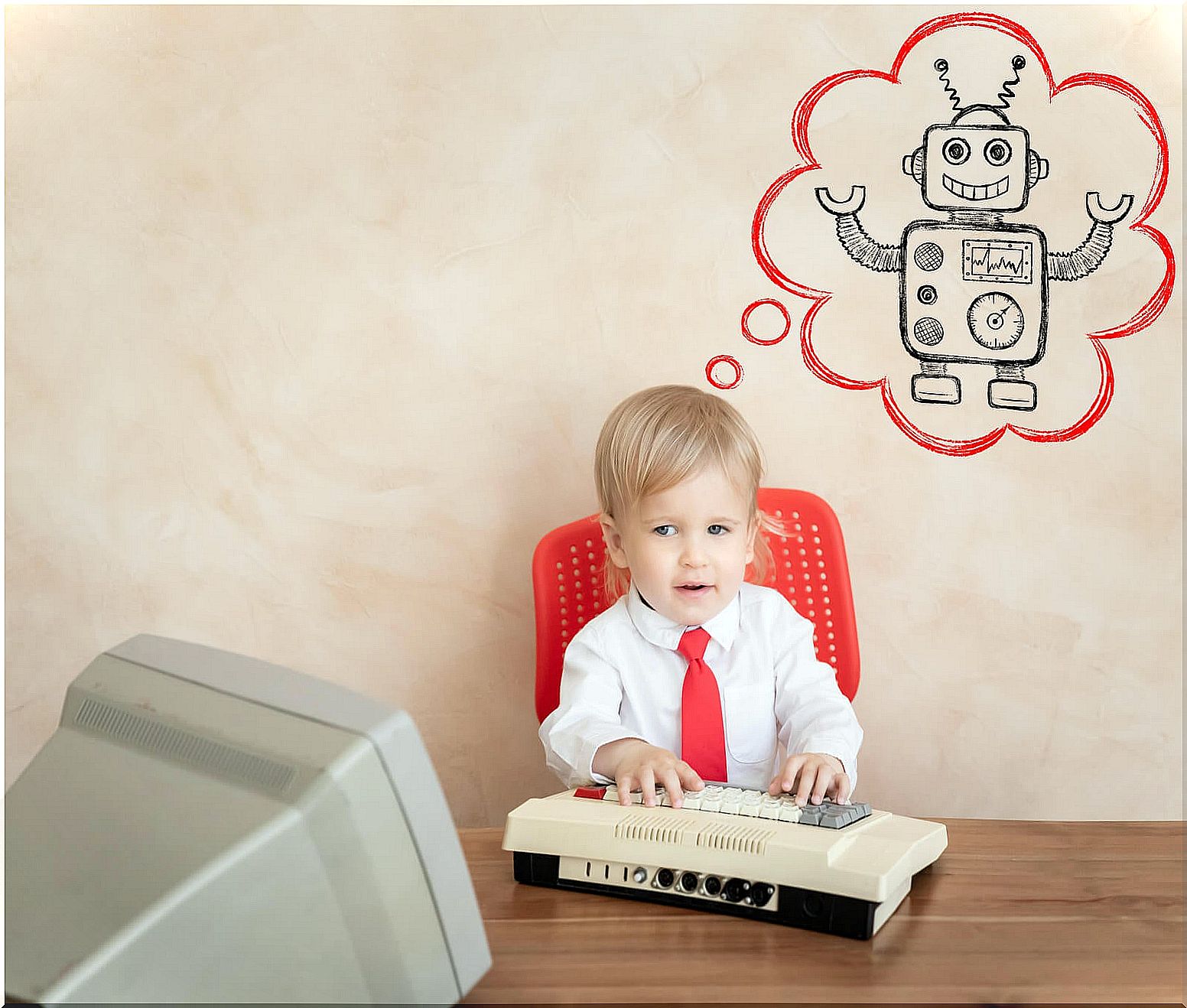 Child with a computer thinking about a robot.