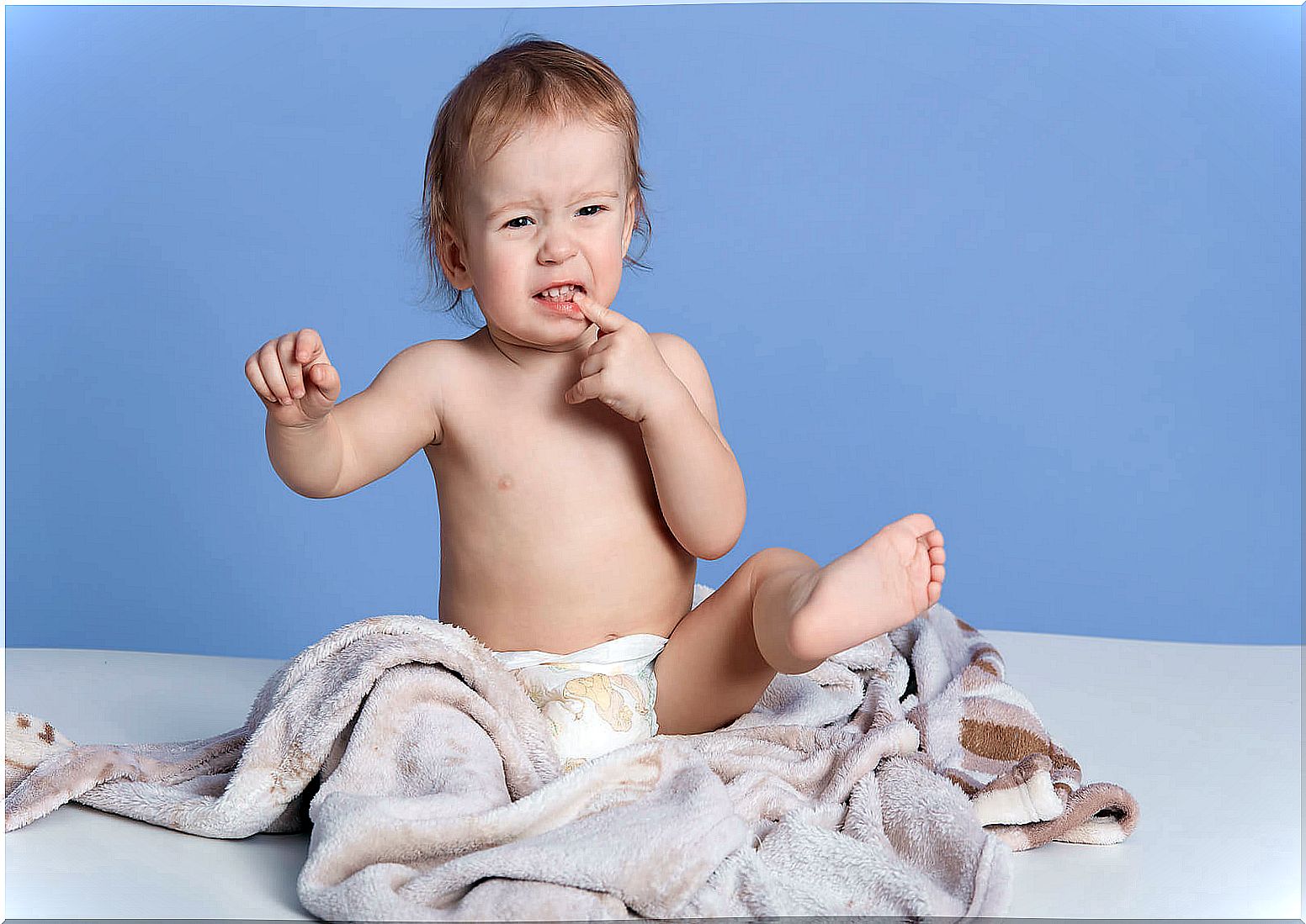 Child with a blanket around to take care of his dry skin.