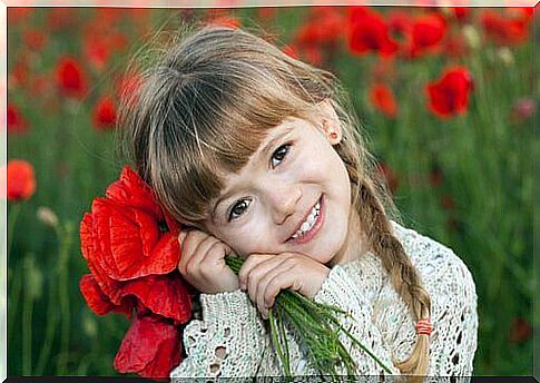 Happy-girl-with-bouquet-of-red-flowers