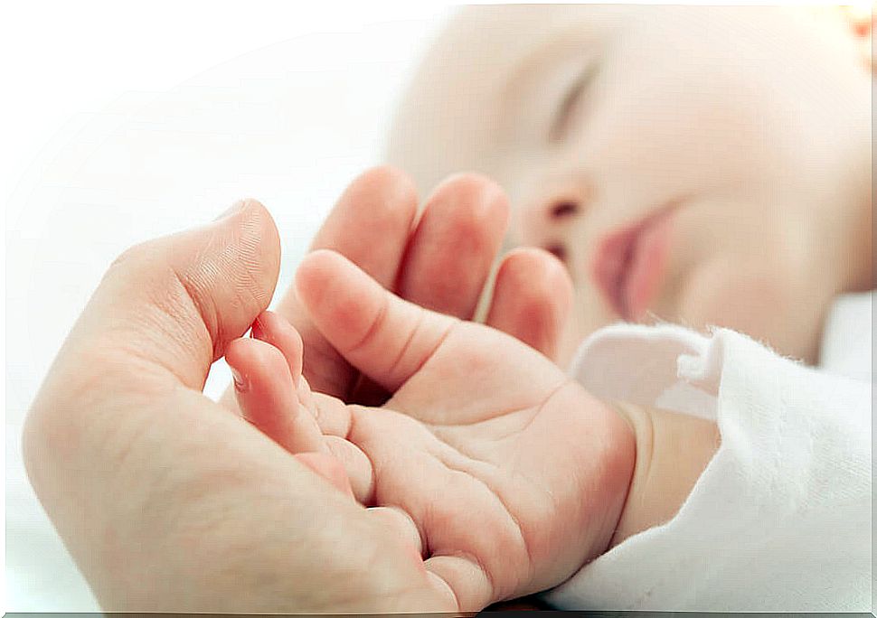 Mother holding her baby's hand.