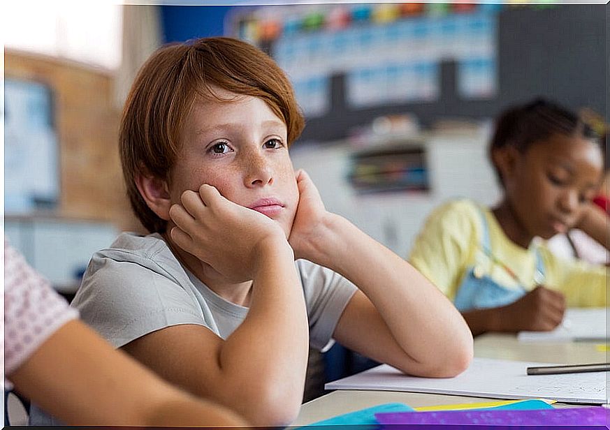 A little sad boy on the first day of class after his change of school.