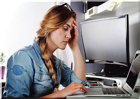 Girl with headache in front of computer screen