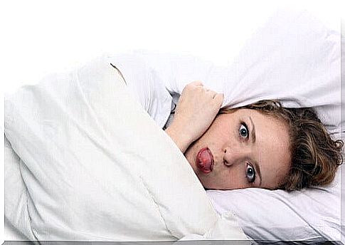 Woman in bed stuffy due to headache during pregnancy