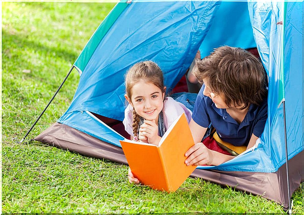 Children reading Isadora Moon books in a tent.