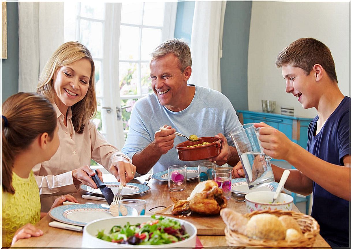 Family eating with their children taking into account infant feeding in stages.