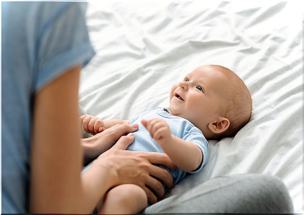 Mother giving her son a massage for the psychological benefits of baby massages.