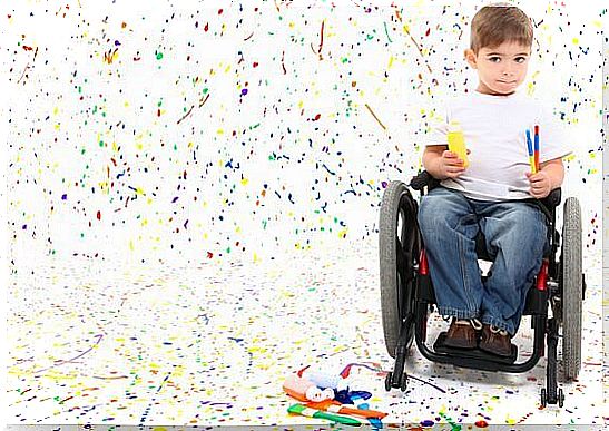 Adorable 2 year old child with wheelchair painting on floor.