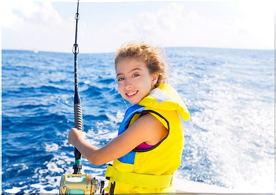 Girl sailing through the sea with life jacket.