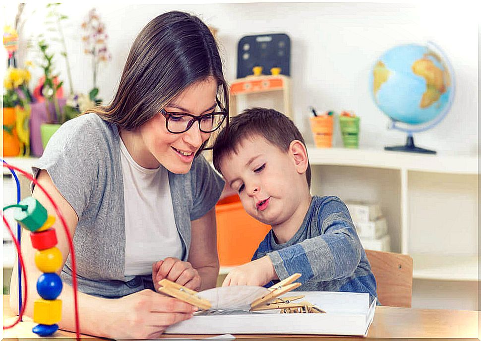 Child with educational compensation needs being helped by his teacher.