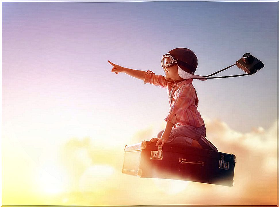 Boy flying over a book thanks to the freedom of children and their imagination.