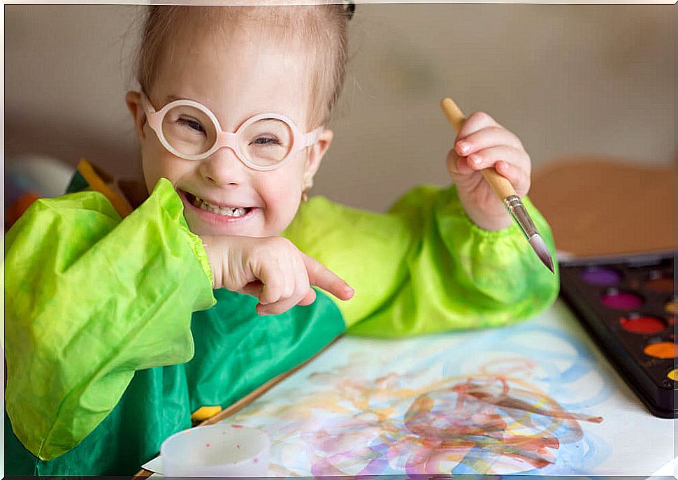 Disabled girl making a drawing with watercolors.