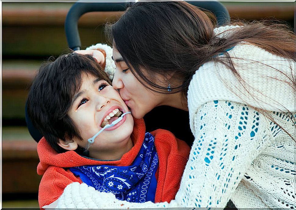 Mother kissing her disabled son.