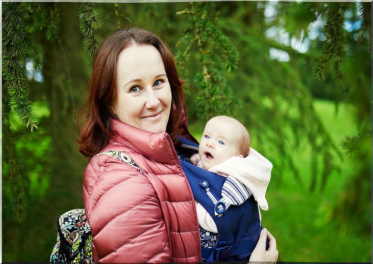 Mother wearing an ergonomic carrying backpack.