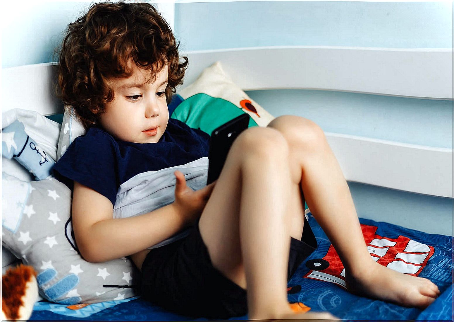 Child playing with the mobile because he is not aware that the mobile phone is not a toy for children.