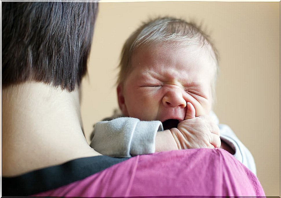 Crying baby in his father's arms.